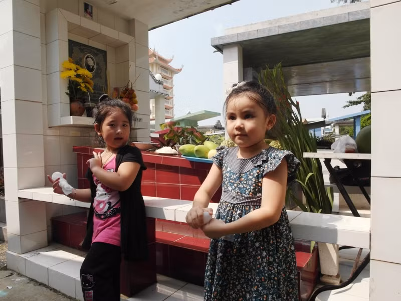 Bí Ngô (con gái của diễn viên Lê Tuấn Anh) và Hạt Dẻ (con gái của MC Quyền Linh) bên mộ của Lê Công Tuấn Anh.