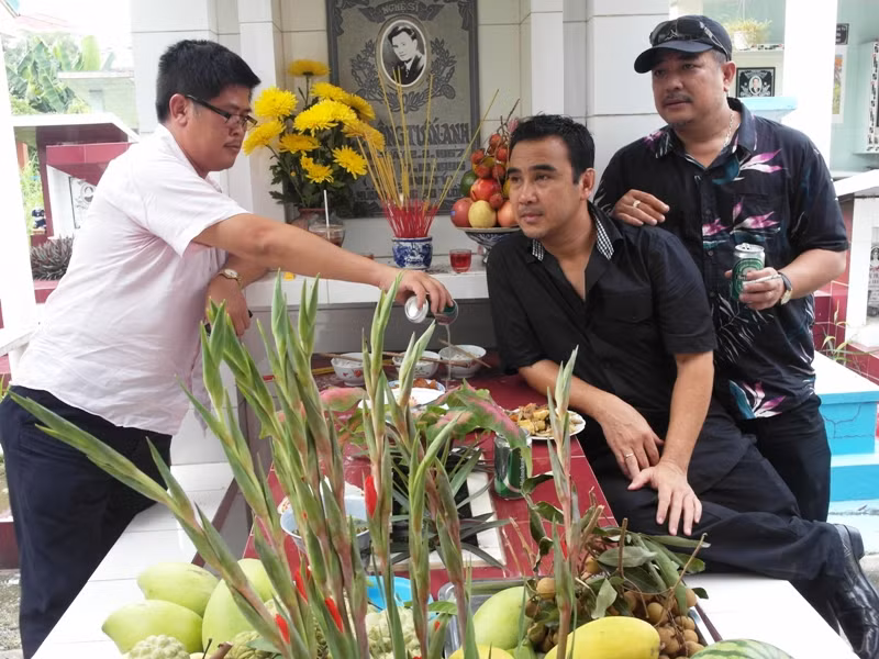 Phước Sang cầm bia rót cho bạn và nói: "Mày về uống với tụi tao chút bia nè...."
