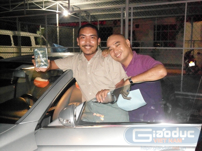 Chung Minh cười vui khi cầm tờ giấy chứng nhận sở hữu chiếc xe Mercedes biển số 51A-127.02.