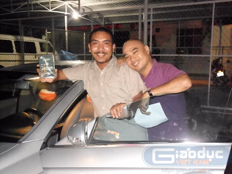Chung Minh cười vui khi cầm tờ giấy chứng nhận sở hữu chiếc xe Mercedes biển số 51A-127.02.