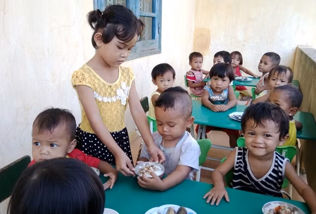 Giúp cô giáo mang cơm cho bạn…(Ảnh: Hoàng Hà)