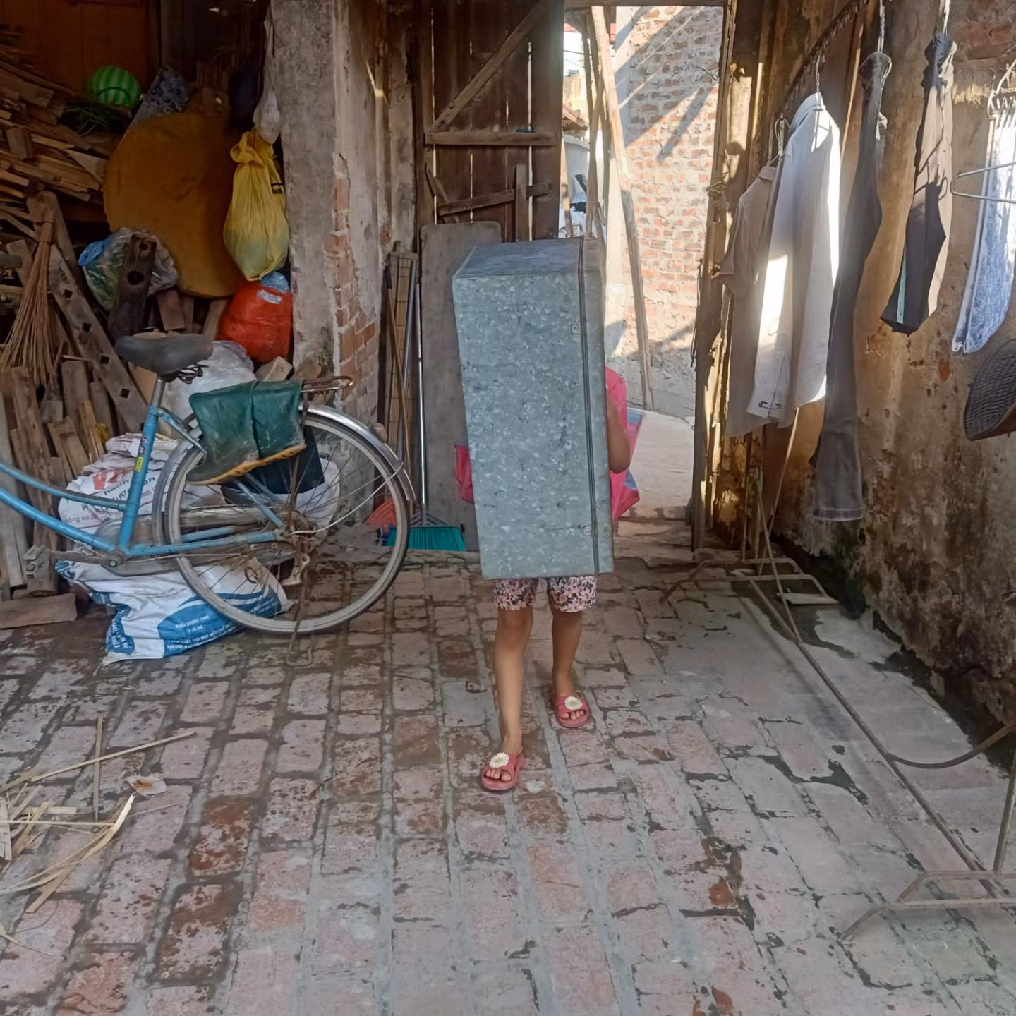 Cô con gái út của chị Bến vất vả khiêng chiếc hòm từ nhà hàng xóm về, sau khi kết thúc buổi học online.