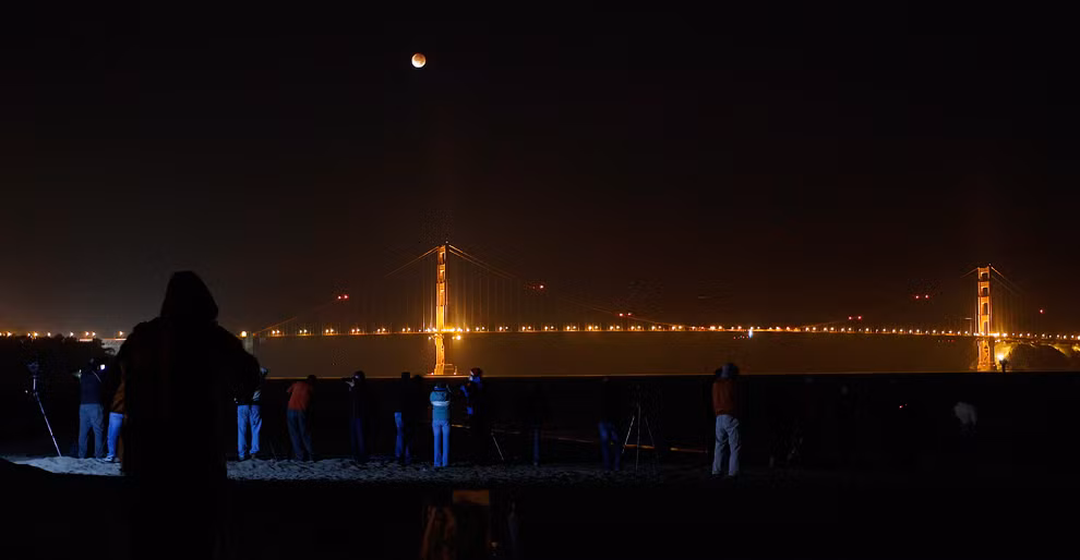 Người dân đứng xem nguyệt thực ở tháp phía Bắc của cầu Cổng Vàng, San Francisco, Mỹ.