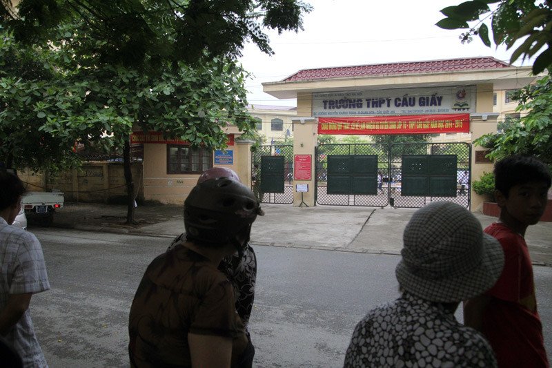 Những phụ huynh ngóng trông con bên ngoài cổng trường.