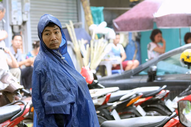 Cơn mưa không làm phụ huynh rời vị trí chờ con.