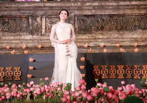 Na Uy thu hút mọi ánh nhìn với tà áo trắng thướt tha của nhà thiết kế Công Khanh. Vẻ đẹp nền nã của cô được tôn vinh với tà áo dài xuất hiện trên nền sân khấu đầy hoa sen. (Theo Vnexpress)