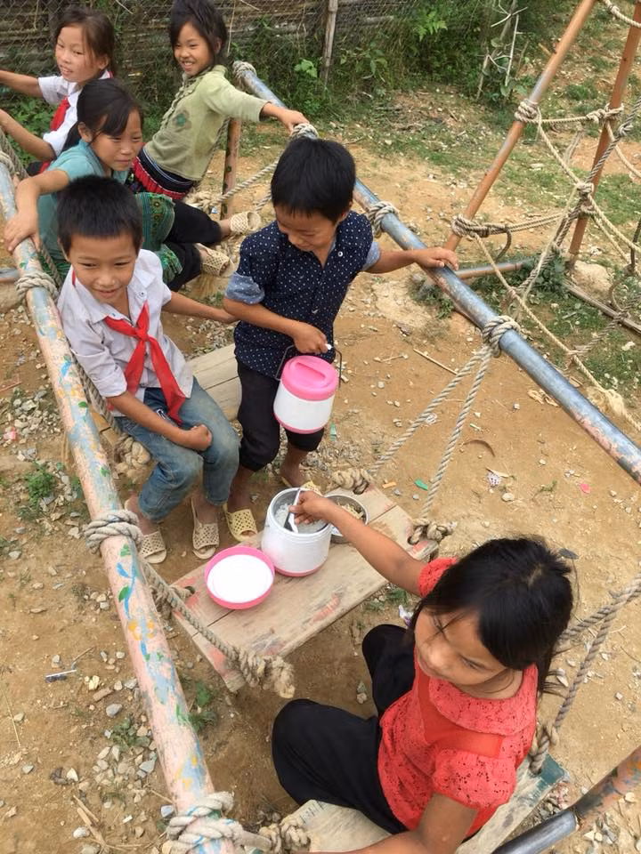 Giờ cơm bán trú của học sinh trường Tiểu học Nậm Chảy. Giờ cơm, các em vẫn ăn trong lớp học, một số em chọn cách ra ngoài ăn cho vui. Bàn ăn nằm trong khu vui chơi của trường, trong vất vả, khó khăn, các em vẫn chọn cho mình những niềm vui nho nhỏ như thế. (Ảnh: Thầy giáo Triệu Quí Toàn)