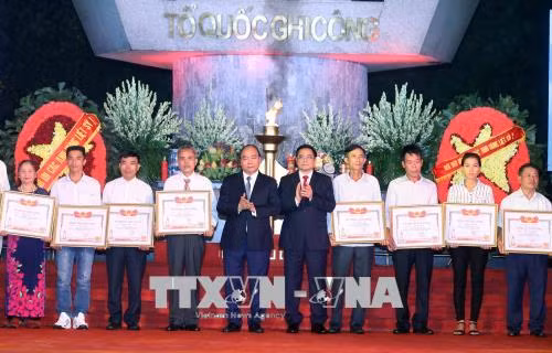Thủ tướng Nguyễn Xuân Phúc và đồng chí Phạm Minh Chính trao Bằng Tổ quốc ghi công cho thân nhân các gia đình liệt sĩ. Ảnh: Thống Nhất/TTXVN