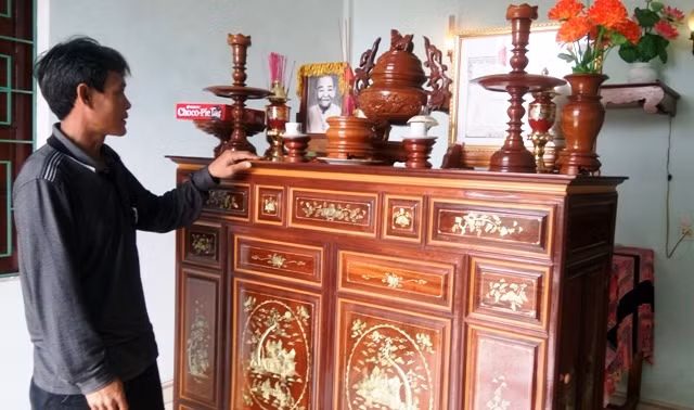 Anh Lợi bên bàn thờ của ông bà nuôi. (Ảnh: Thủy Phan) Anh Lợi bên bàn thờ của ông bà nuôi. (Ảnh: Thủy Phan)
