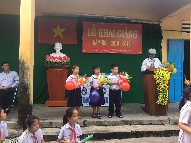 Đại diện học sinh lớp 1 nhận hoa của học sinh lớp 5