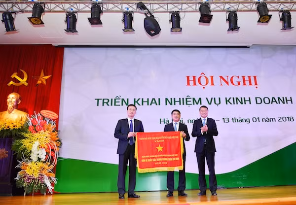 Ông Lê Minh Hưng - Ủy viên Ban chấp hành Trung ương Đảng, Bí thư Ban Cán sự Đảng, Thống đốc Ngân hàng Nhà nước Việt Nam (bên phải) thừa ủy quyền của Thủ tướng Chính phủ trao Cờ thi đua cho Vietcombank – Đơn vị xuất sắc trong phong trào thi đua