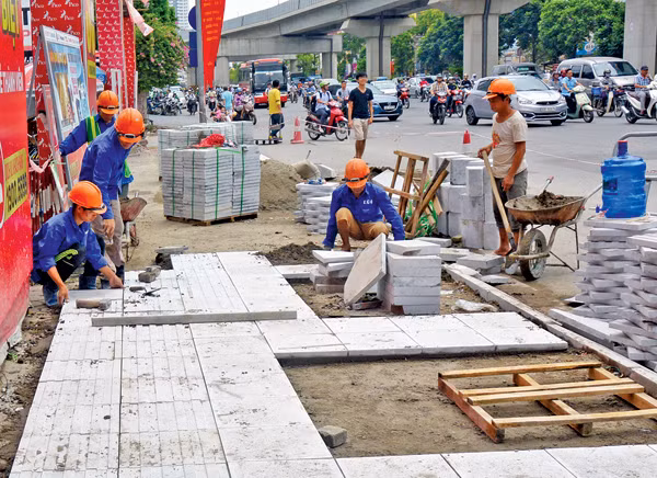 Cảnh thi công lát đá tự nhiên cho vỉa hè tại Hà Nội. (Ảnh minh hoạ: Baogiaothong.vn)