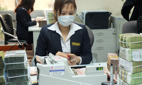 Nhiều ngân hàng đã thu phí nộp tiền mặt vào tài khoản. Ảnh minh họa: Thanh Lan.