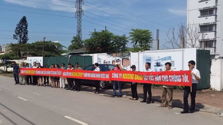Khách hàng giăng biểu ngữ tố cáo Housing Group tại Dự án Khu nhà ở kinh doanh (ảnh nguồn Báo Đầu tư BĐS) Khách hàng giăng biểu ngữ tố cáo Housing Group tại Dự án Khu nhà ở kinh doanh (ảnh nguồn Báo Đầu tư BĐS)