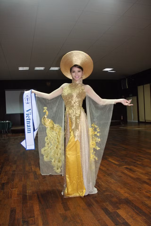 Bộ áo dài thêu công, màu vàng của nhà thiết kế Võ Việt Chung đã tạo cho Hương Thảo nét dịu dàng, nữ tính, nổi bật khi đứng cạnh các người đẹp khác tại buổi thi Trang phục truyền thống vào sáng 8/9. Đây là phần thi phụ của cuộc thi Hoa hậu Siêu Quốc gia năm 2012 đang diễn ra tại Ba Lan.