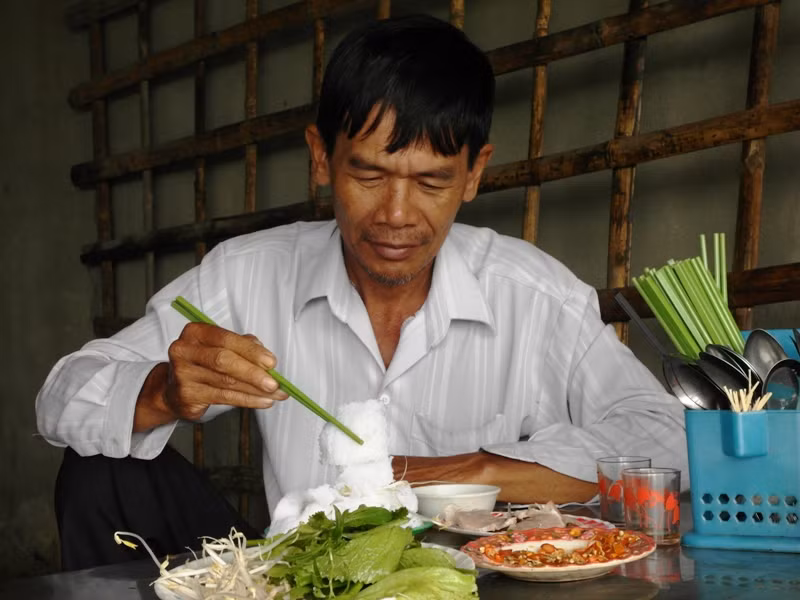 Một lão nông đang ngồi nhấm nháp bánh hỏi với cháo lòng. Thỉnh thoảng lão nông cầm ly, nhấp chút rượu đế. Có lẽ ngà ngà, lão lấy hơi, cất câu vọng cổ mùi mẫn bài "Tình anh bán chiếu" của danh ca quá cố Út Trà Ôn: "Ghe chiếu Cà Mau đã cắm sào trên dòng sông Ngã Bảy....Cô gái năm xưa sao không thấy ra chào...". Giữa không gian yên tĩnh, nghe giọng ông ,như "cảm" đựoc cả hồn quê hương sông nước. Một lão nông đang ngồi nhấm nháp bánh hỏi với cháo lòng. Thỉnh thoảng lão nông cầm ly, nhấp chút rượu đế. Có lẽ ngà ngà, lão lấy hơi, cất câu vọng cổ mùi mẫn bài "Tình anh bán chiếu" của danh ca quá cố Út Trà Ôn: "Ghe chiếu Cà Mau đã cắm sào trên dòng sông Ngã Bảy....Cô gái năm xưa sao không thấy ra chào...". Giữa không gian yên tĩnh, nghe giọng ông ,như "cảm" đựoc cả hồn quê hương sông nước.