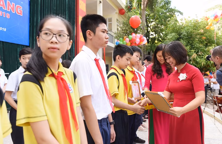 Cô giáo Hoàng Kim Uyên - Phó Hiệu trưởng Trường Trung học Cơ sở Giảng Võ trao phần thưởng, động viên học trò bước vào năm học mới. ảnh: Hải Phong.