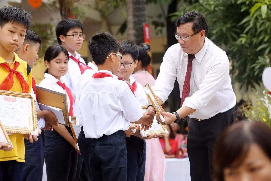 Thầy Lê Việt Trung - Phó Hiệu trưởng nhà trường tặng giấy khen cho học trò. ảnh: Hải Phong.