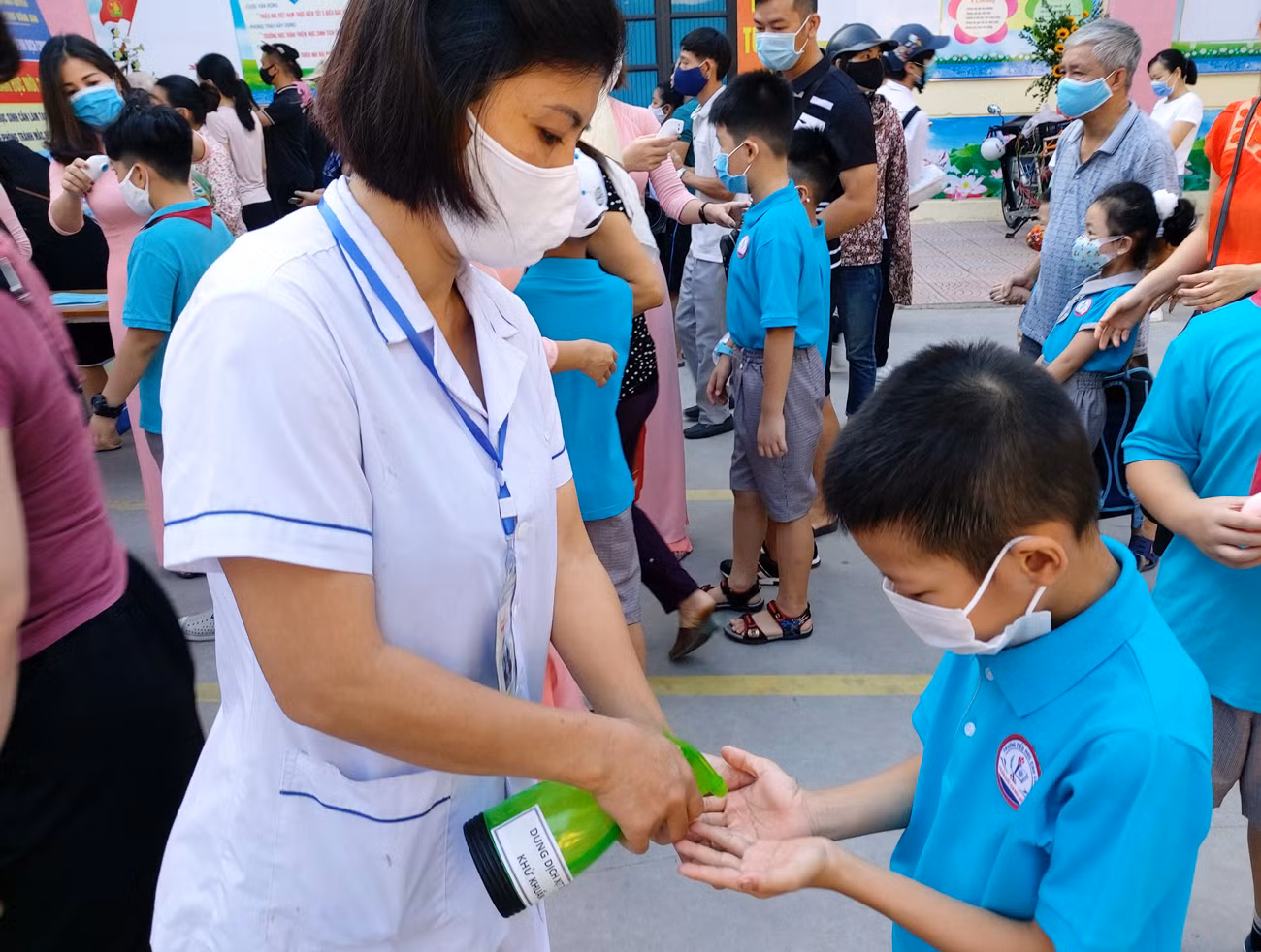 Học sinh được khử khuẩn tay trước cổng trường (Ảnh: Lã Tiến)