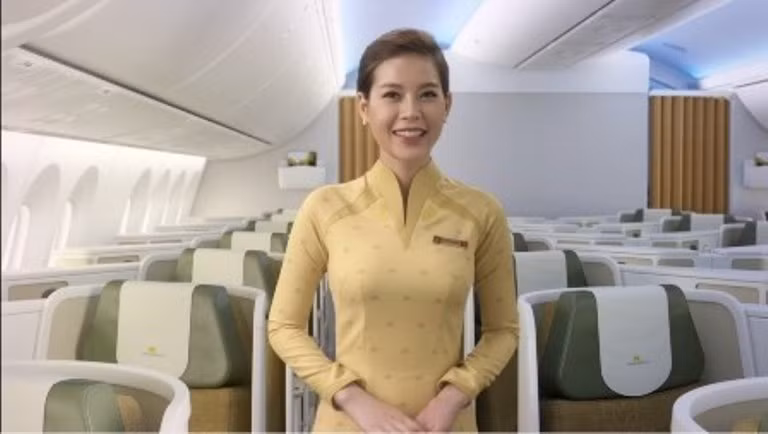 Tiếp viên nữ của khoang thương gia (hạng C) mặc áo dài màu vàng nhạt