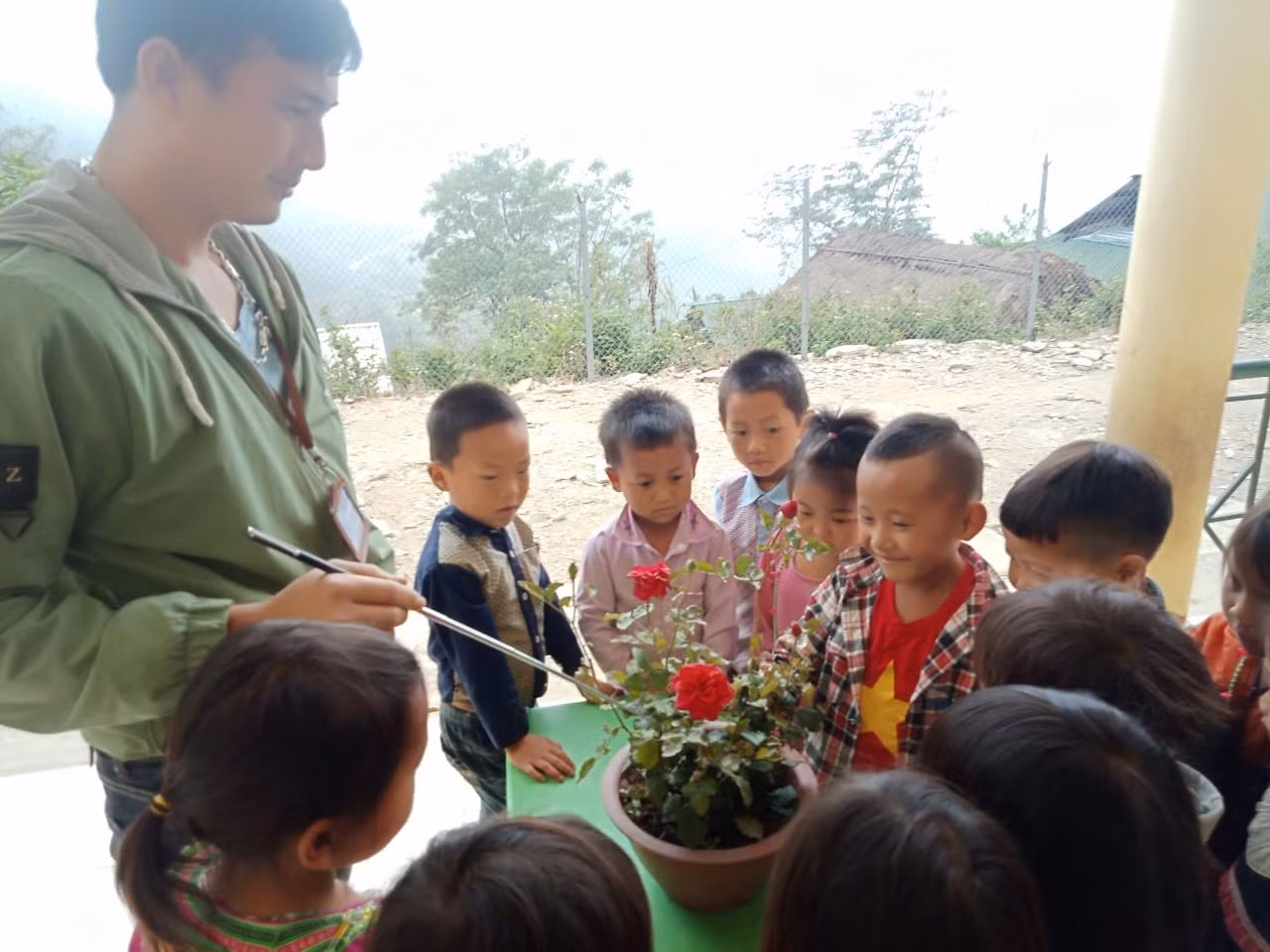 Một giờ hoạt động ngoài trời, thầy Công giới thiệu cho các em về các loài hoa để các em biết yêu thiên nhiên, bảo vệ môi trường. Ảnh: NVCC.
