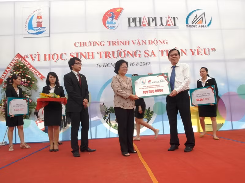 Ông Lê Chí Hiếu - Tổng giám đốc công ty Cổ phần phát triển nhà Thủ Đức (Thu Duc House) đang trao cho bà Trương Mỹ Hoa 109.590.000 đồng, đóng góp vào quỹ "Vì học sinh Trường Sa thân yêu".