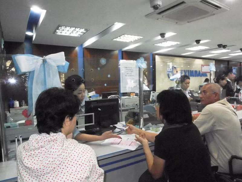 Một nhân viên đang giải thích lãi suất gửi tiền dài hạn tại ngân hàng. Một nhân viên đang giải thích lãi suất gửi tiền dài hạn tại ngân hàng.