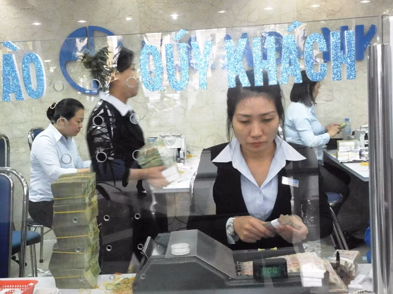 Cô nhân viên đang cần mẫn ngồi kiểm soát số tiền khách gửi chiều nay bằng máy đếm. Cô nhân viên đang cần mẫn ngồi kiểm soát số tiền khách gửi chiều nay bằng máy đếm.