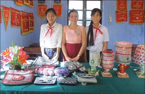 Hình cô Kim Anh cùng 2 em Thư và Thuận bên những món đồ thủ công mỹ nghệ tự sáng chế (Ảnh: tác giả cung cấp).