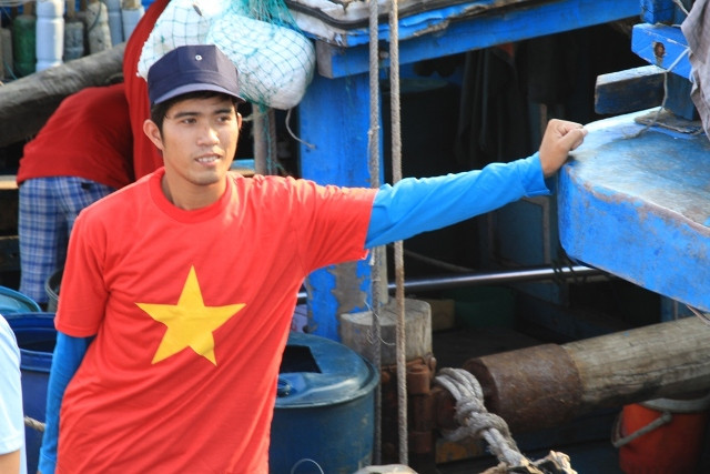Một ngư dân trẻ không khỏi dấu được cảm xúc khi mang trên mình chiếc áo in hình lá cờ Tổ quốc. Anh đứng nép ở một góc tàu. "Đây là một chuyến đi biển đặc biệt...", ngư dân trẻ này tâm sự.