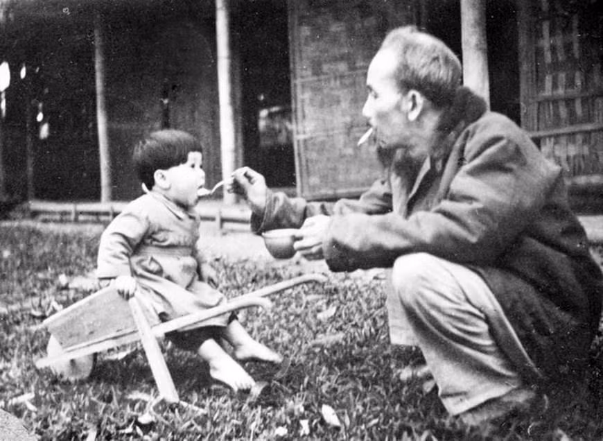 Bác Hồ bón cơm cho một cháu bé khi đến thăm trại nhi đồng ở chiến khu Việt Bắc (1950). (Ảnh: Tư liệu TTXVN) Bác Hồ bón cơm cho một cháu bé khi đến thăm trại nhi đồng ở chiến khu Việt Bắc (1950). (Ảnh: Tư liệu TTXVN)
