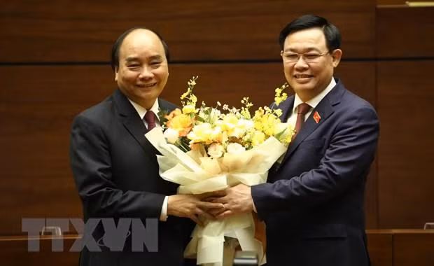Chủ tịch Quốc hội Vương Đình Huệ chúc mừng Thủ tướng Nguyễn Xuân Phúc hoàn thành xuất sắc nhiệm vụ. (Ảnh: Văn Điệp/TTXVN)