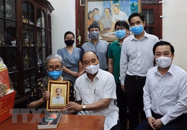 Chủ tịch nước Nguyễn Xuân Phúc đã tới thăm gia đình cố Nhà báo Hữu Thọ. (Ảnh: Thống Nhất/TTXVN)