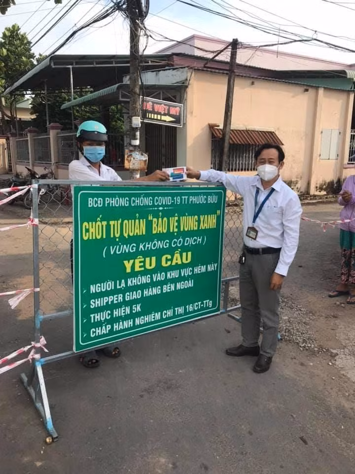 Thầy Lê Văn Chinh, Hiệu trưởng Trường Trung học cơ sở Phước Bửu trao điện thoại cho học sinh học trực tuyến (Ảnh nhà trường cung cấp)