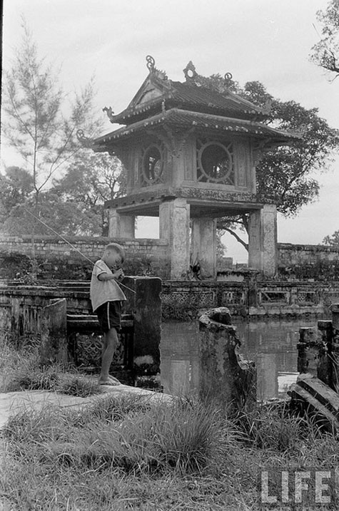 Một cậu bé câu cá bên hồ nước bên trong Văn miếu quốc tử giám vào những năm đầu thế kỷ 20.