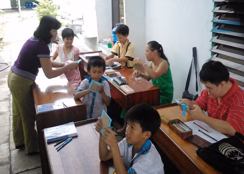 Cô Nga phát giấy, và hướng dẫn cho các em làm lồng đèn vui Tết Trung thu.