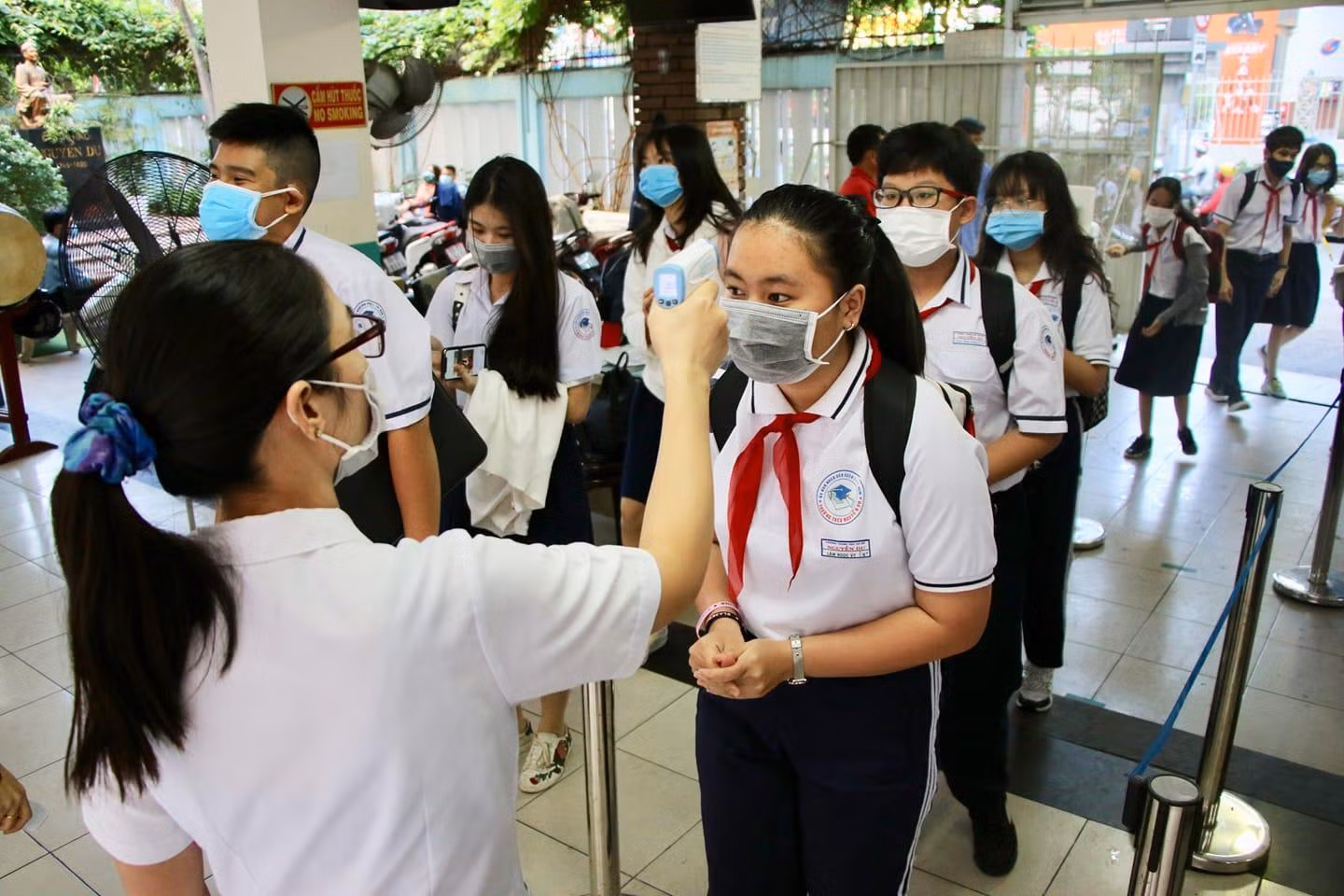 Học sinh trường Trung học cơ sở Nguyễn Du, quận 1 được đo thân nhiệt từ cổng (ảnh: NTCC)