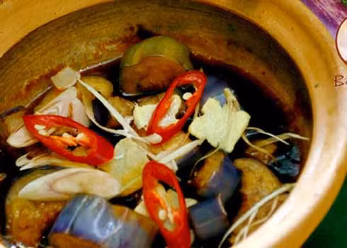 21. Cà tím kho tộ: Cà tím xắt miếng lớn và kho trong nồi đất cùng với cà chua, nước tương, đường, thịt lợn băm nhỏ, khi ăn cho thêm một số loại rau và gia vị. Ăn đâu: quán Bồ đề tâm Số 68 Phạm Huy Thông - Ba Đình - HN