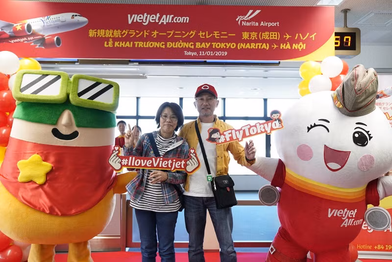 Amy của Vietjet và Kutan của Sân bay Quốc tế Narita chào mừng và chụp ảnh lưu niệm cùng những hành khách đầu tiên của chuyến bay khai trương.