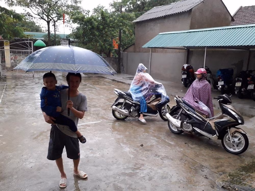 Từ 7h sáng ngày 5/9, phụ huynh Trường mầm non Trường Sơn, Đức Thọ đội mưa đưa con đến khai giảng