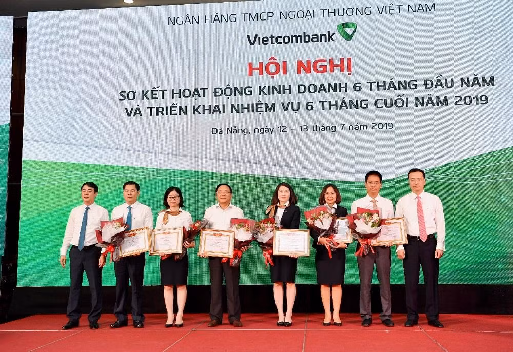 Chủ tịch Hội đồng Quản trị Nghiêm Xuân Thành (ngoài cùng bên trái) và Tổng giám đốc Phạm Quang Dũng (ngoài cùng bên phải) tặng Giấy khen và hoa cho 06 tập thể có thành tích trong hoạt động khoa học