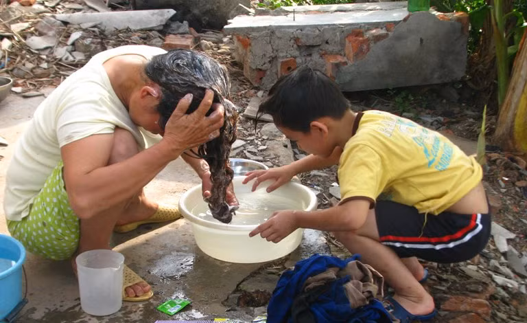 Đi bắt ngao về, cháu Hiếu bắt chước mẹ gội đầu.