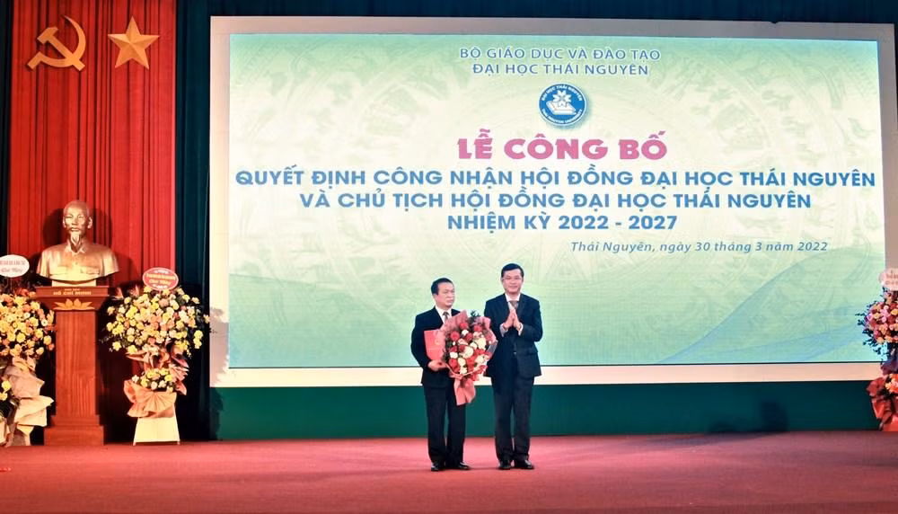 Phó giáo sư Nguyễn Văn Phúc – Phó Bí thư Ban Cán sự Đảng, Thứ trưởng Bộ Giáo dục và Đào tạo trao quyết định và tặng hoa chúc mừng Giáo sư Phạm Hồng Quang – Bí thư Đảng ủy, Chủ tịch Hội đồng Đại học Thái Nguyên (Ảnh: NTCC)