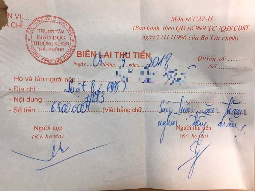 Trung tâm Giáo dục thường xuyên Hải Phòng viết biên lai thu tiền học phí cho học viên học văn bằng 2 Khoa Luật Kinh tế của Trường Đại học Đông Đô (Ảnh: Lã Tiến)