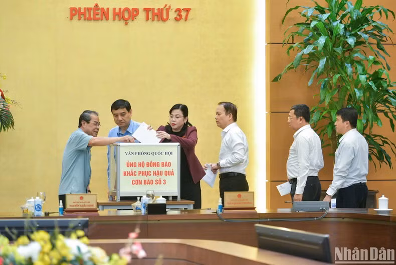 Các Ủy viên Ủy ban Thường vụ Quốc hội ủng hộ đồng bào khắc phục hậu quả cơn bão số 3. (Ảnh: Duy Linh)