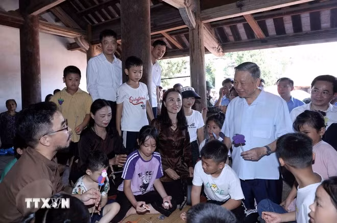 Chủ tịch nước Tô Lâm thăm hỏi thiếu nhi trải nghiệm làm tò he truyền thống tại đình Mông Phụ, làng cổ Đường Lâm. (Ảnh: Nhan Sáng/TTXVN)