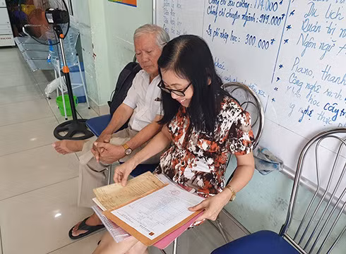 Cô Đào Thị Thư kiểm tra lại các loại giấy tờ, bằng cấp trước khi vào làm thủ tục nhập học (ảnh: P.L)