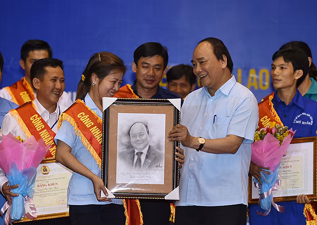 Công nhân tặng Thủ tướng Nguyễn Xuân Phúc bức ký họa chân dung Thủ tướng. ảnh: VGP.