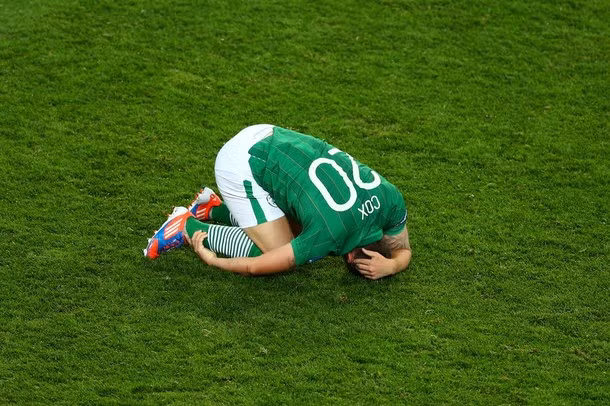 Cầu thủ Simon Cox của Ireland nằm úp mặt xuống sân sau khi trận đấu kết thúc.
