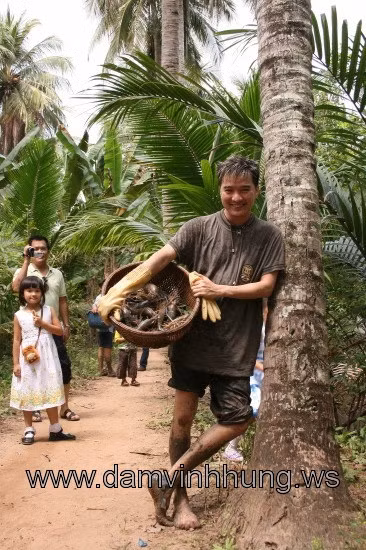Mr Đàm lấm lem bùn đất bê rổ tôm.